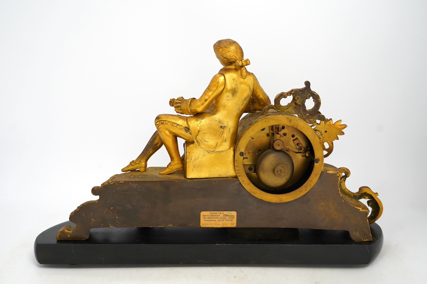 A 19th century figurative ormolu mantel clock, with floral porcelain panels, on stand with key and pendulum, stand approximately 39cm wide. Condition - clock dial cracked, clock untested as working